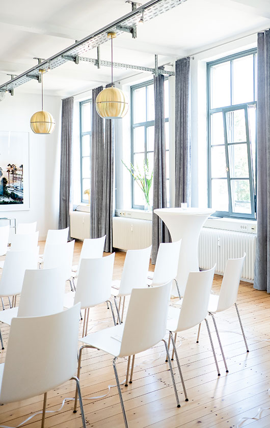 Weiße Stühle in einem hellen lichtdurchfluteten Loft