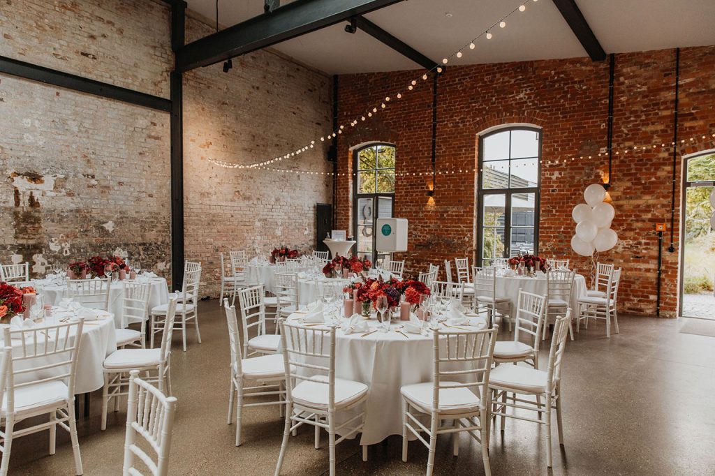 Eine gedeckte Hochzeitstafel ohne Personen in einer Halle