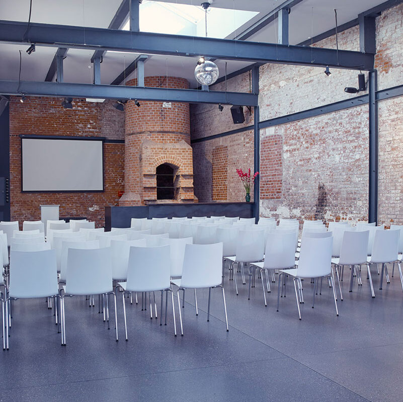 Tagungsraum mit weißen Stühlen für Tagungen und Seminare